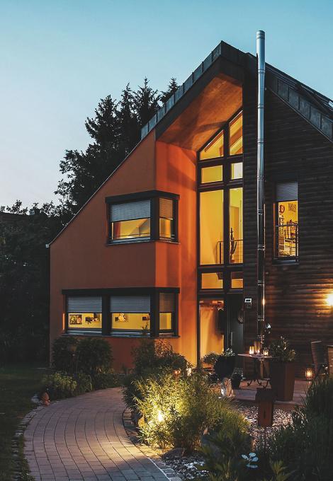 House in the twilight with interior lighting and half closed roller shutters