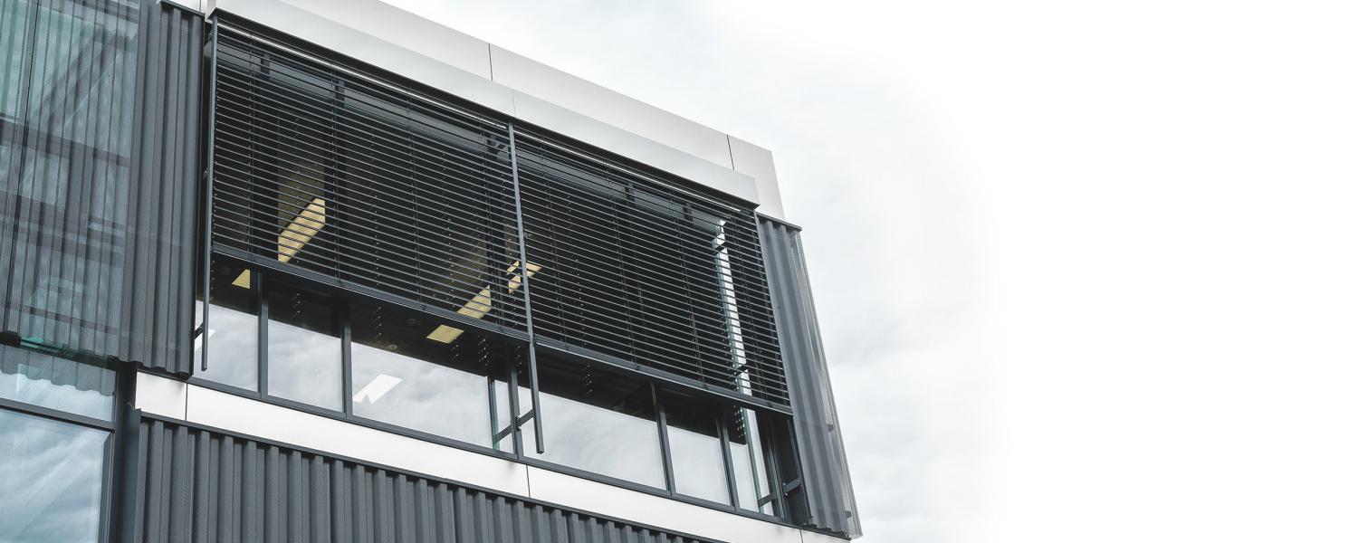 Modern office building by daylight with façade venetian blinds
