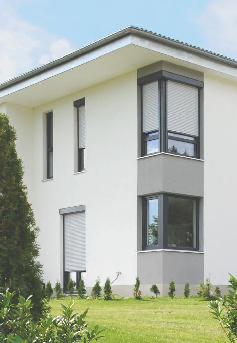 Flat roof single-family home with partly closed roller shutters by daylight