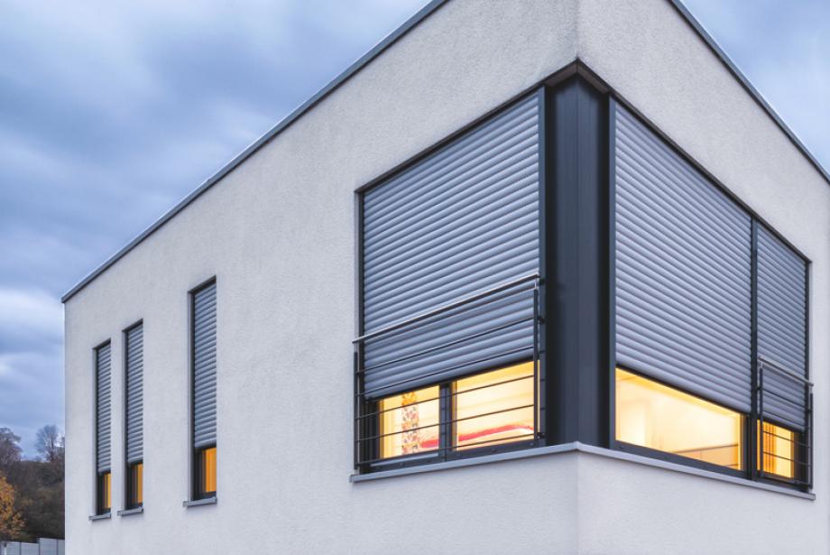 Flat roof single-family home detailed view windows with nearly closed roller shutters