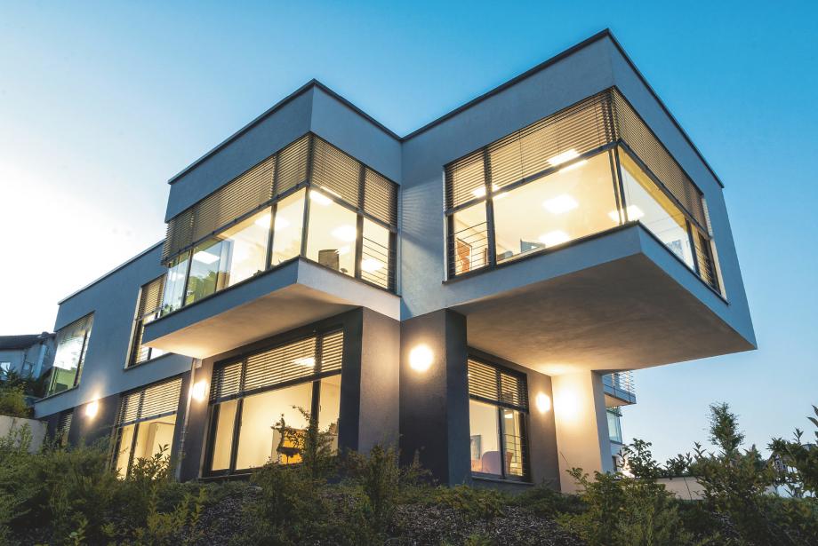 Flat roof office building on a slope with interior lighting in the twilight