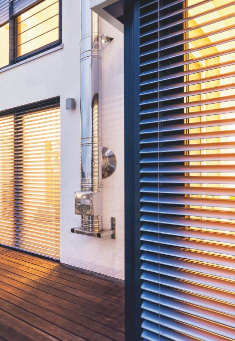 Patio with seating area in the twilight and with view to ROMA half-opened external venetian blinds