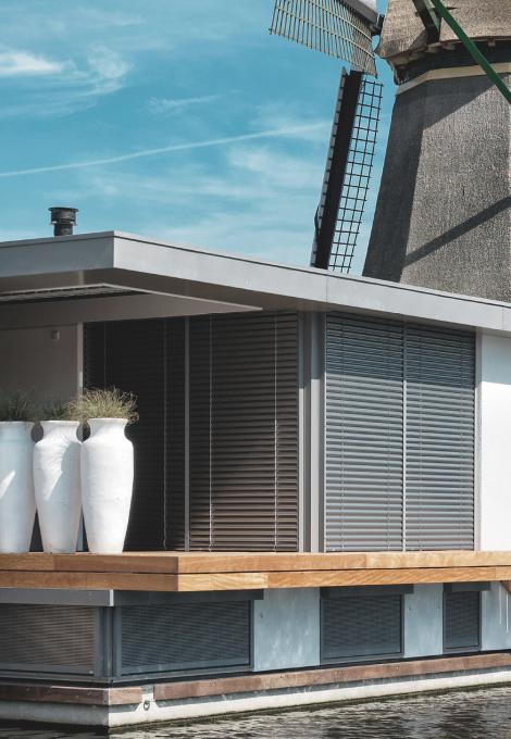Houseboat detailed view by daylight with windmill, closed external venetian blinds