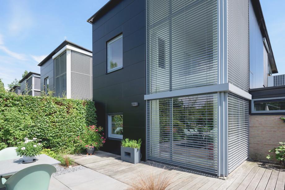 Modern residential building with patio by daylight, lowered external venetian blinds, tilting position 90°