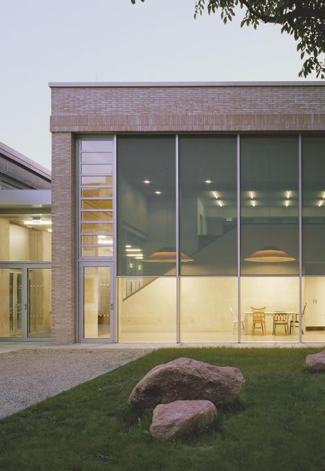 Children's day care facility with glass front with interior lighting and textile screens in the twilight