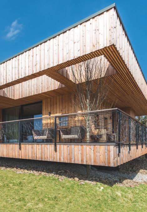 Chalet exterior view patio and lawn by daylight