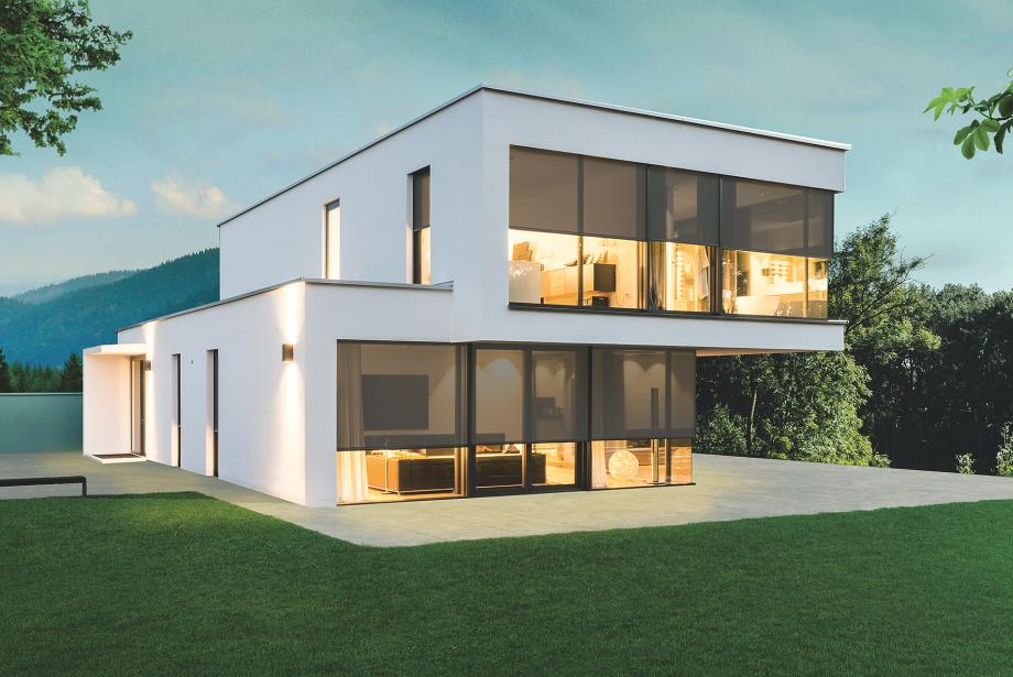 Modern model home in the twilight with interior lighting, textile screens