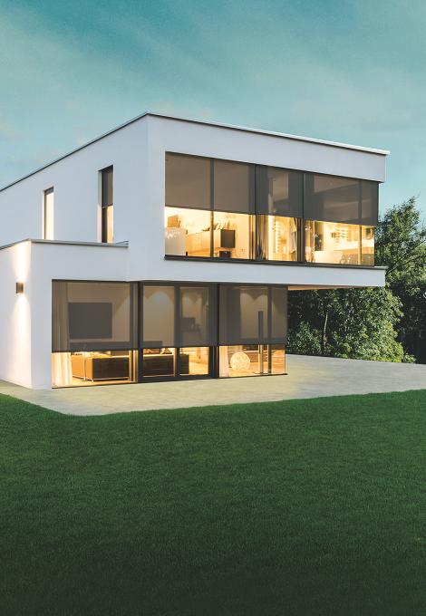 Modernes Modellhaus bei Dämmerung mit Innenbeleuchtung und Textilscreens