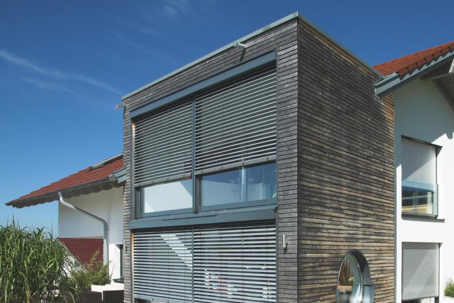 Wooden construction of house with front-mounted external venetian blinds by daylight