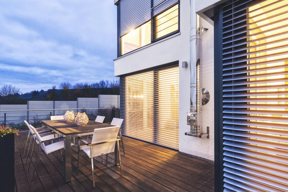 Patio with seating area in the twilight and with view to ROMA half opened external venetian blinds