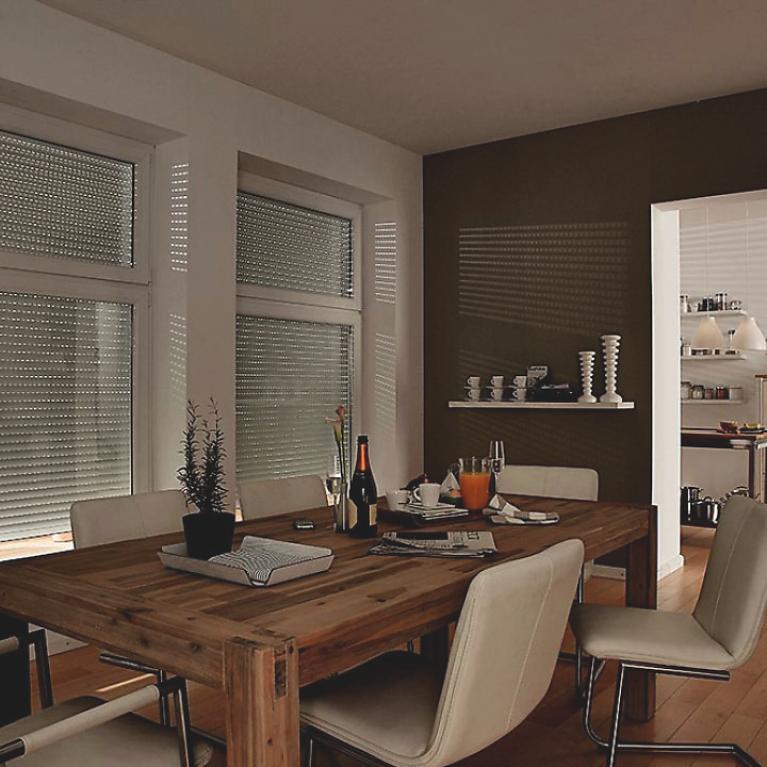 Dining room by daylight with closed roller shutters