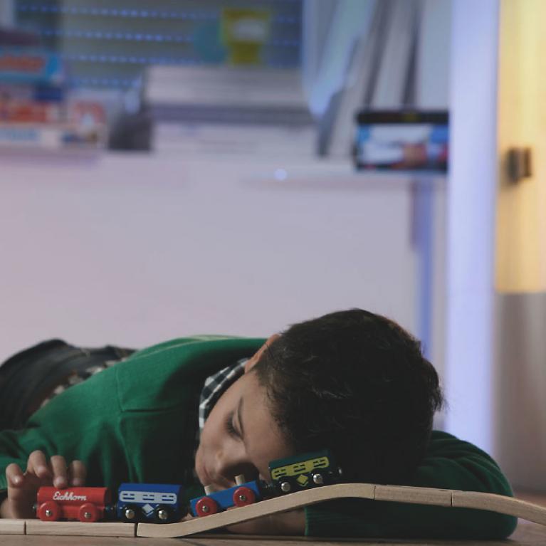 Children lies on the floor with railway, sleeping