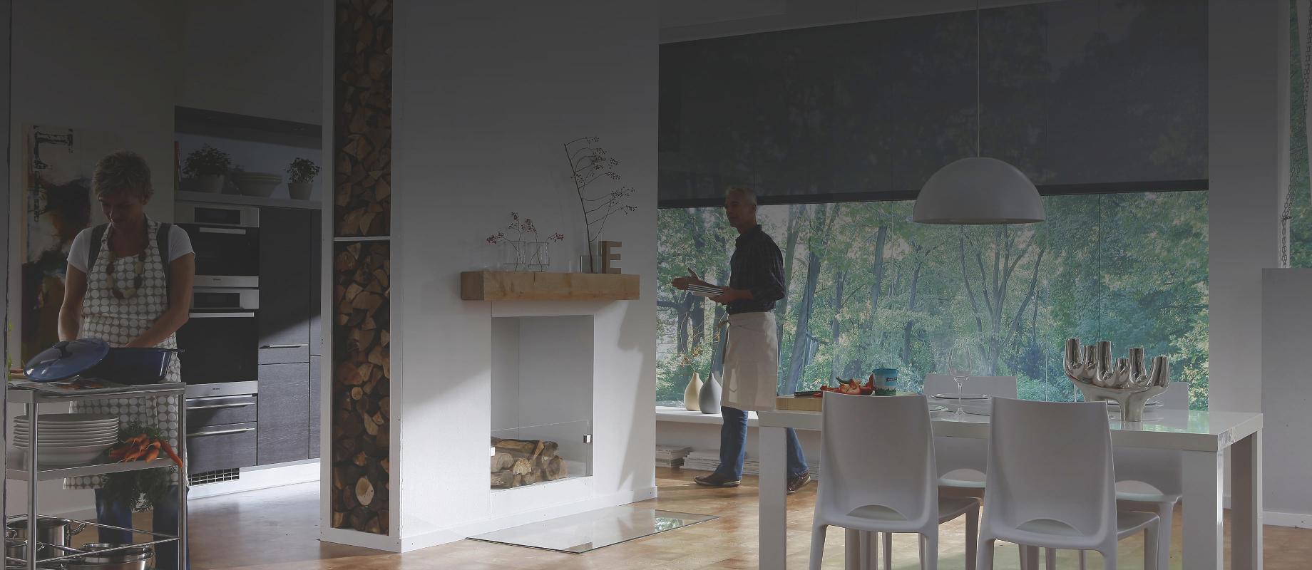 Dining area with open kitchen and cooking woman and a man