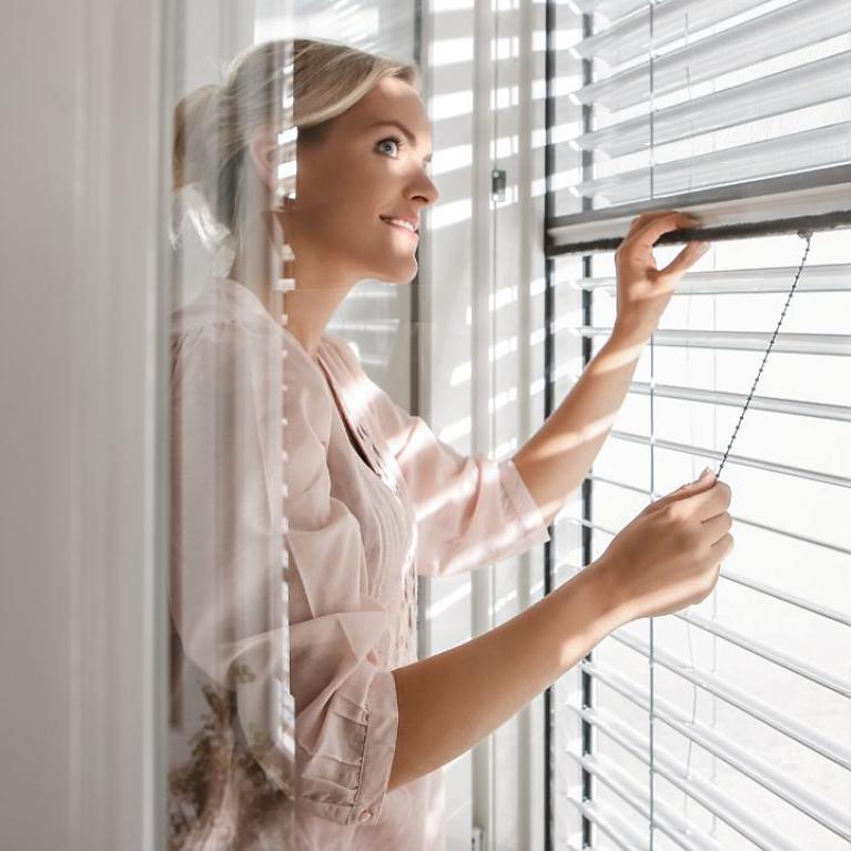 Interior view, woman closes insect screen, external venetian blinds, tilting function 90°