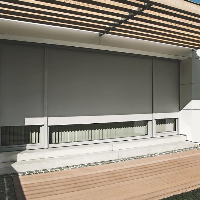 Detailed view balcony with window front and lowered textile screens by daylight