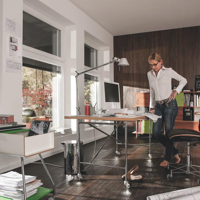 Office from the inside with half lowered textile screens by daylight