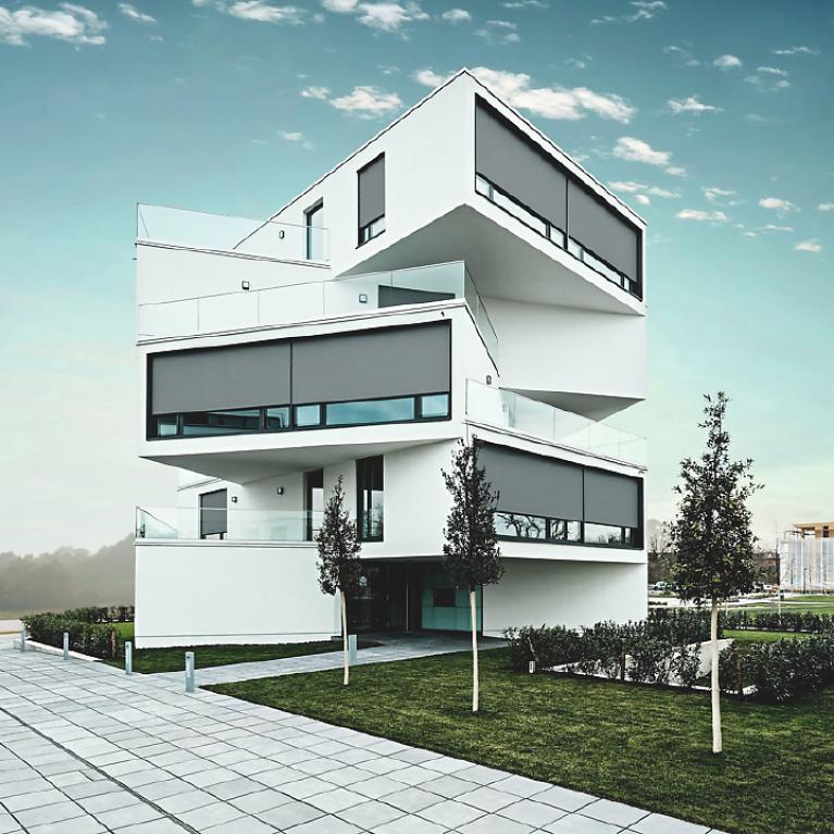 Modern, five-storied nested house with nearly lowered front-mounted textile screens by daylight