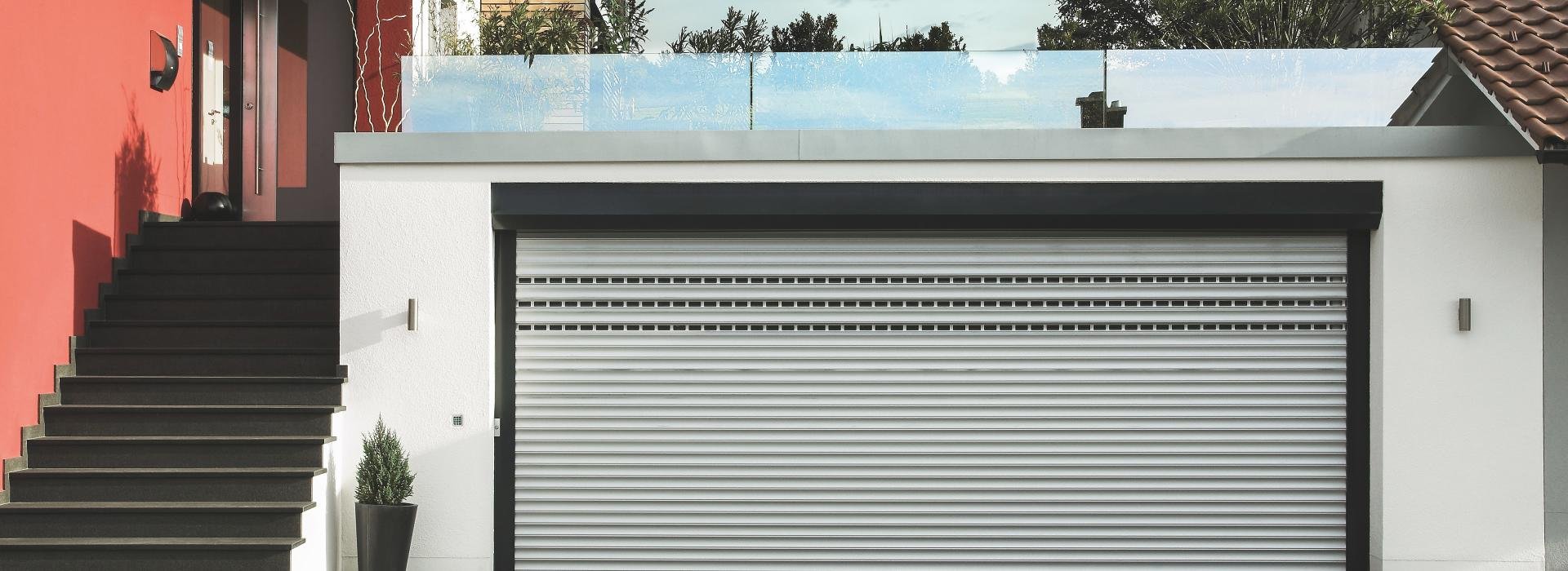 House entrance with staircase, part of a garage with rooftop patio