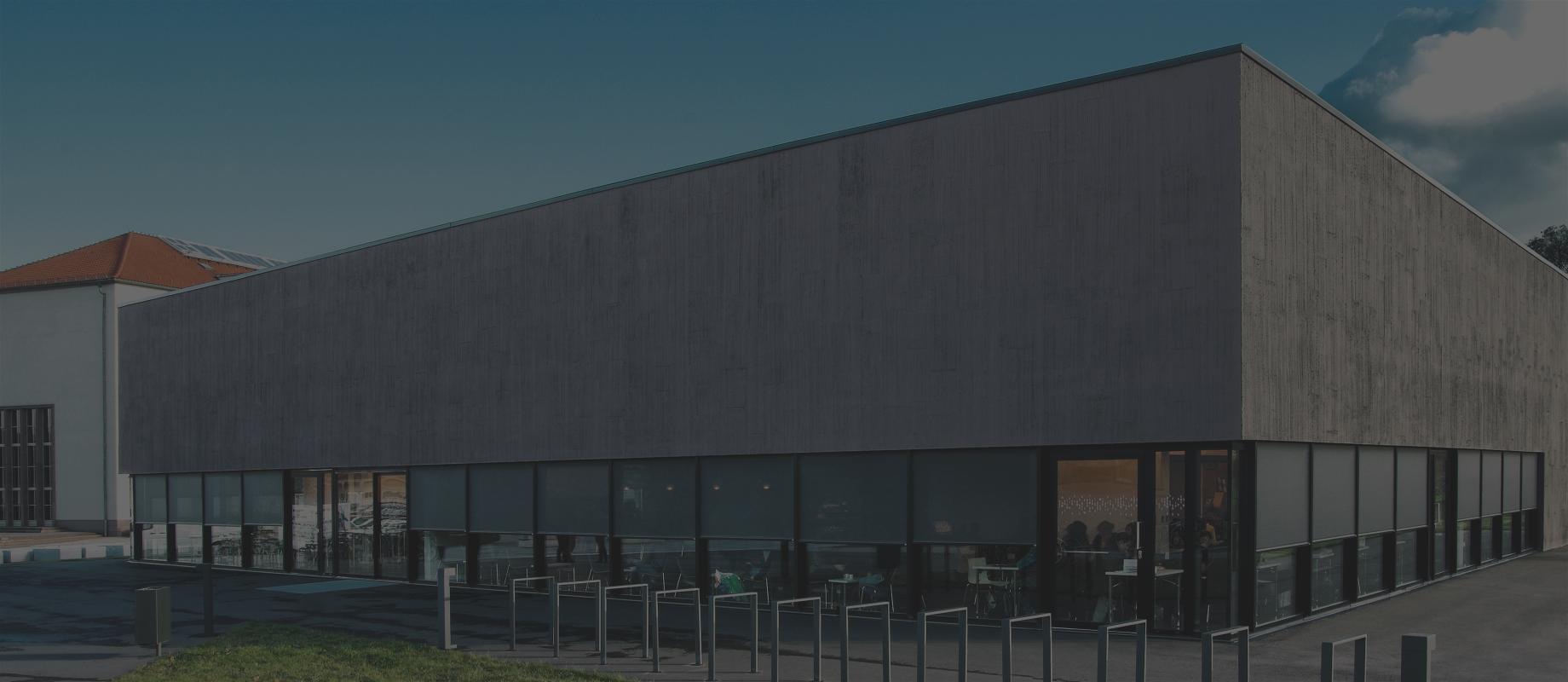 Modern, two-storied building with surrounding window front and front-mounted textile screens