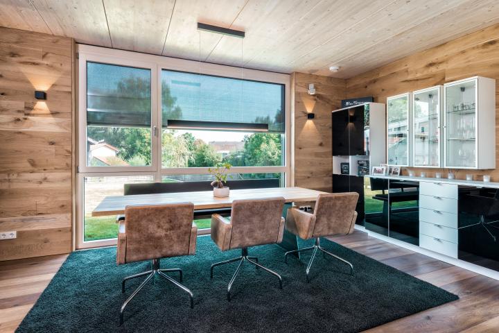 Dining room with internior lighting and lowered external venetian blinds, tilting position 90°