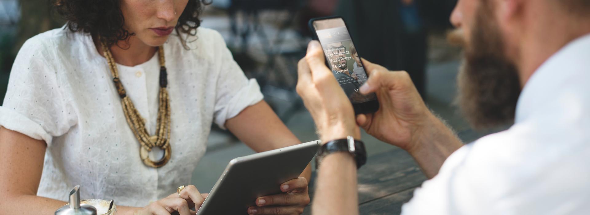 Woman and man in a cafe with mobile devices