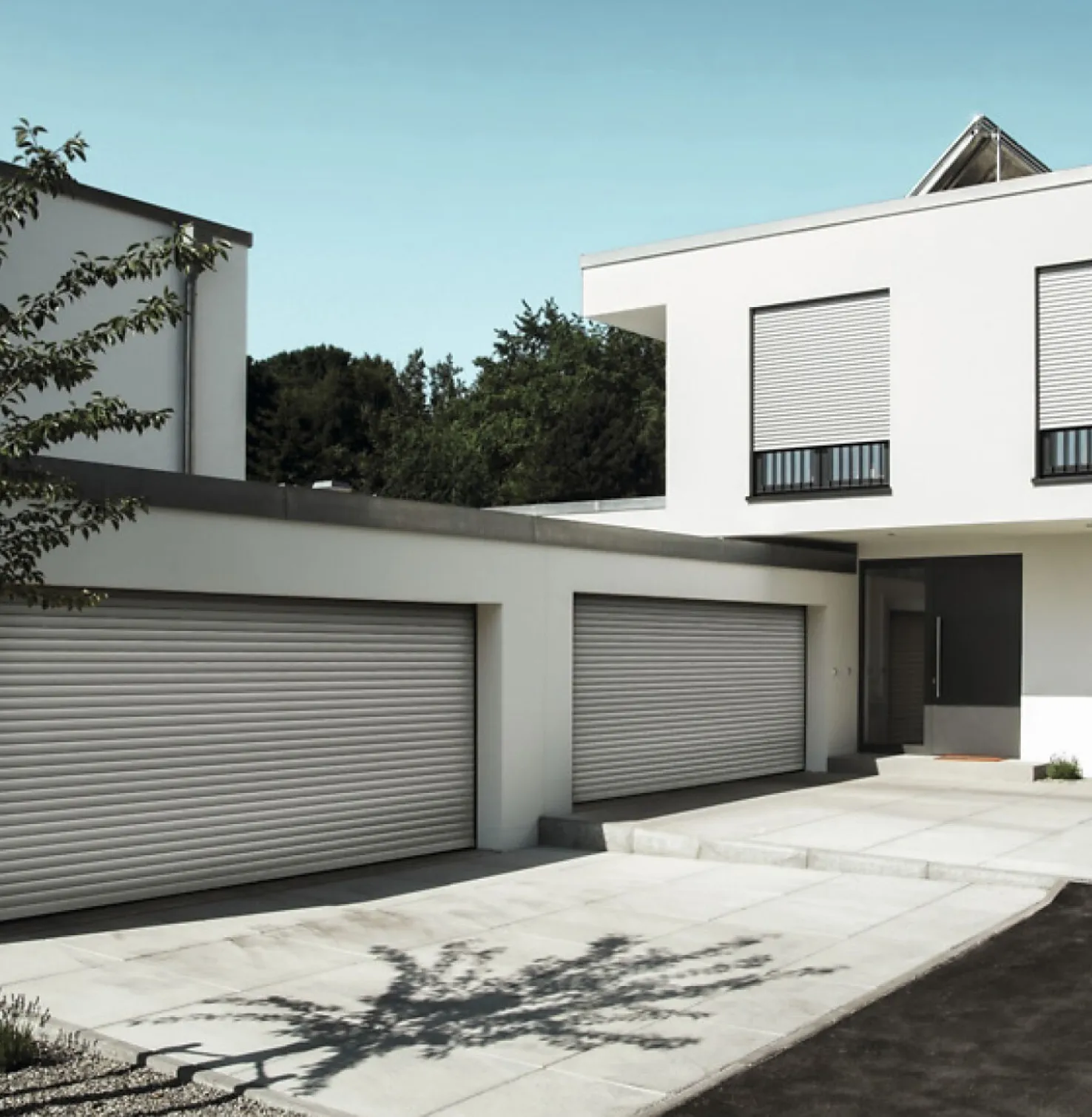 Haus bei Tag mit zwei Doppelgaragen und zwei ROMA Deckenlauftore